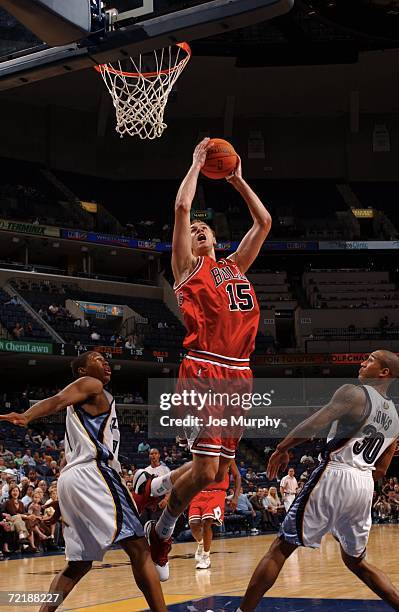 Martynas Andriuskevicius of the Chicago Bulls dunks over Dahntay Jones and Kyle Lowry of the Memphis Grizzlies during a preseason game on October 16,...