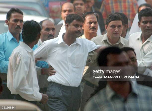 Indian prisoner Santosh Singh is led away by police officials from Delhi High Court in New Delhi, 17 October 2006, after being convicted for rape and...