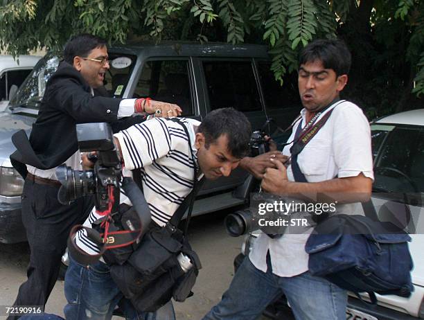 An Indian lawyer assaults press photographers as they cover the murder trial of unseen Santosh Singh at Delhi High Court in New Delhi, 17 October...