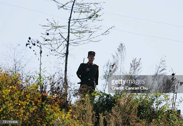 North Korean border guard walks on the banks of the Yalu River, opposite the Chinese border city of Dandong on October 17, 2006 in Uiju, Democratic...