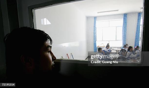 Uygur ethnic minority man looks throw a window of the class at a local Uygur-Chinese bilingual education middle school on October 13, 2006 in Hotan...