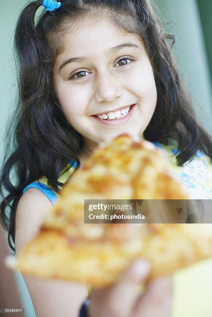 Portrait of a girl holding a slice of pizza