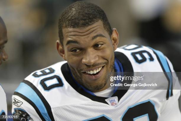 Defensive lineman Julius Peppers of the Carolina Panthers smiles while talking to teammates on the sideline during a preseason game against the...