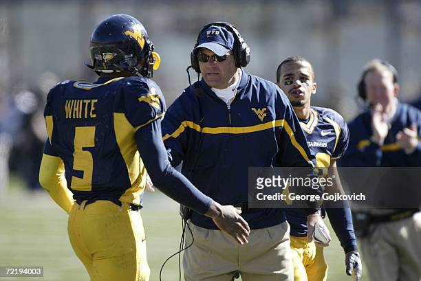 Head coach Rich Rodriguez of the West Virginia University Mountaineers talks with quarterback Pat White on the sideline during a game against the...