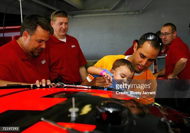 Juan Pablo Montoya, driver of the Texaco/Havoline Ganassi Racing Dodge,gives his son Sebastian his first look from inside a NASCAR Nextel Cup car as...