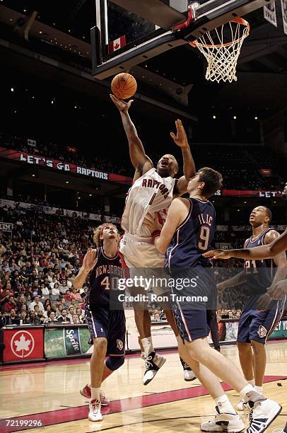 Tucker of the Toronto Raptors goes to the basket goes to the basket under pressure from Mile Ilic and Matt Walsh of the New Jersey Nets during the...
