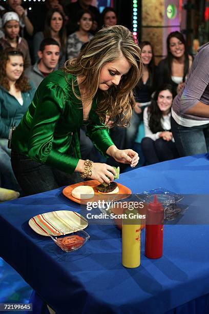 Singer JoJo makes a hamburger during a contest with an audience member during MTV's Total Request Live at the MTV Times Square Studios October 17,...