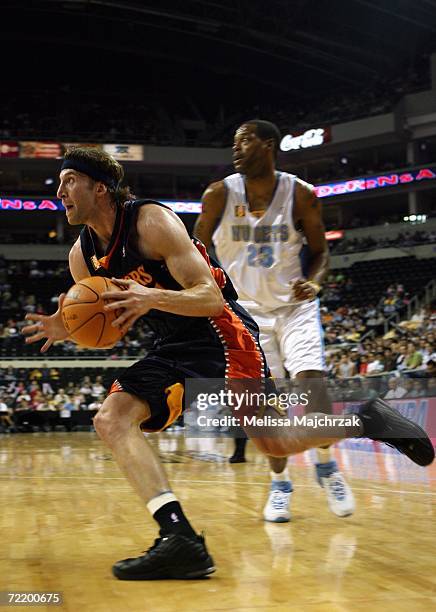 Troy Murphy of the Golden State Warriors drives to the basket past Marcus Camby of the Denver Nuggets during a preseason game at the Arena Monterrey...