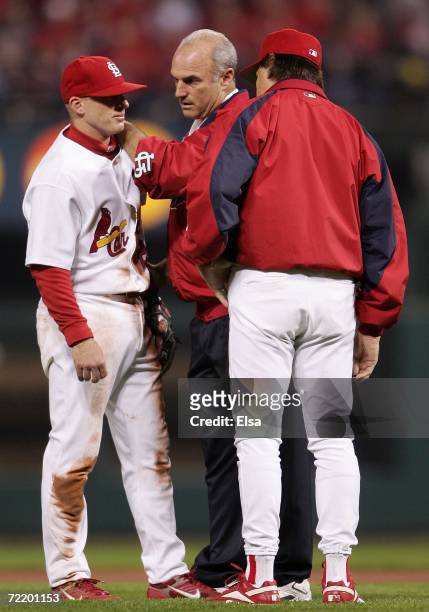 David Eckstein of the St. Louis Cardinals is tended to by a trainer and manager Tony La Russa during a game against the New York Mets during game...