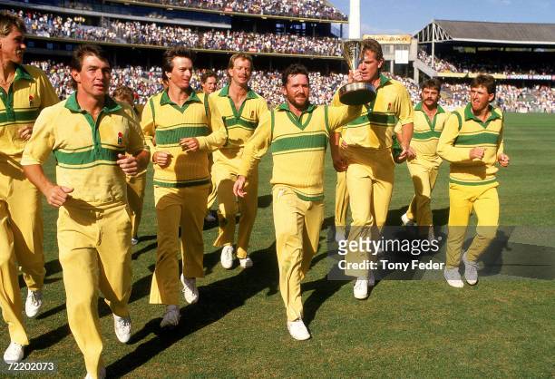 Allan Border of Australia holds aloft the world series cup after the Benson & Hedges World Series Cup 2nd final match between Australia and India at...