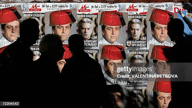 Passer-by look at disfigured posters of incumbent socialist president Georgy Parvanov "wearing" a Turkish fez, and ultra-nationalist candidate Volen...