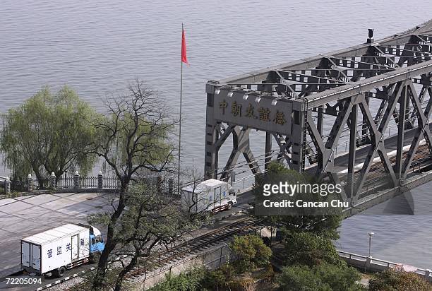 Chinese trucks heading towards North Korea line up on the China-North Korea Friendship Bridge over the Yalu River as they wait for inspection by...