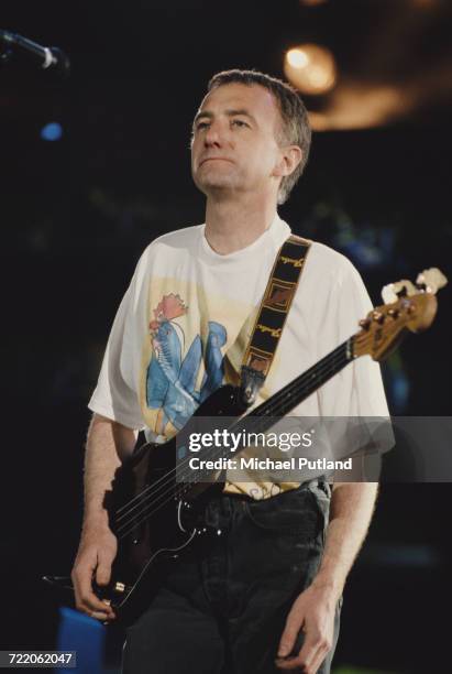 English bass guitarist John Deacon of rock group Queen performs live onstage with the band at the Freddie Mercury Tribute Concert at Wembley Stadium...