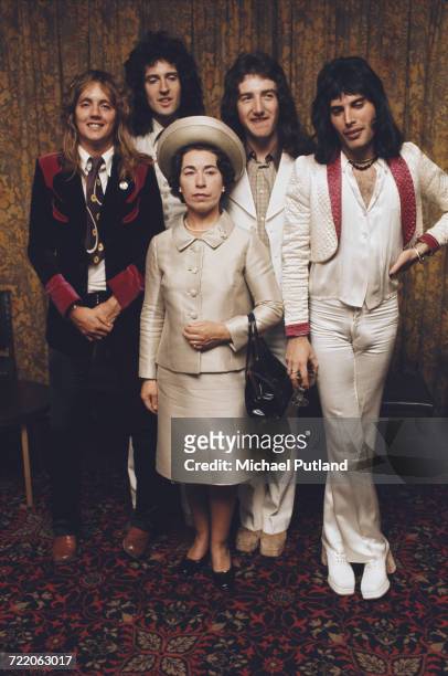 British rock band Queen posing with actress and Queen Elizabeth II look-alike, Jeannette Charles, September 1974. The group are drummer Roger Taylor,...