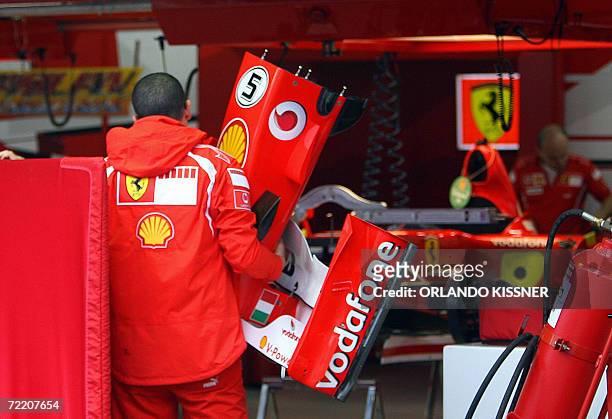Mechanic of Ferrari F1 team carries the front spoiler of German Michael Schumacher's car, 18 October 2006, at the Interlagos race track in Sao Paulo,...
