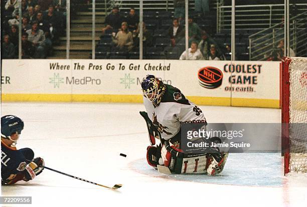 Goalkeeper Nikolai Khabiblulin of the Phoenix Coyotes focuses on the puck as he drops to his knees to make a pad save on a point blank shot by Jim...