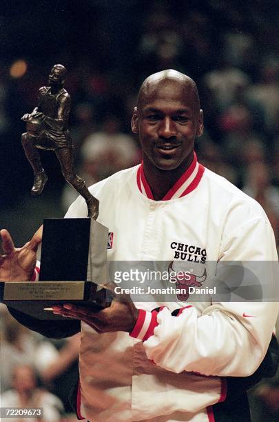 Michael Jordan of the Chicago Bulls holds up the MVP trophy before the Eastern Conference game against the Indiana Pacers at the United Center in...