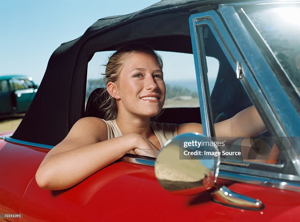 Young woman in a red car