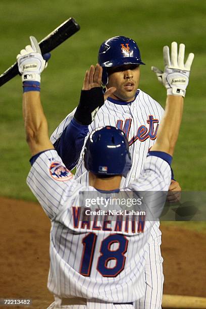 Carlos Beltran of the New York Mets is greeted by teammate Jose Valentin after scoring on a RBI single by Shawn Green in the fourth inning against...