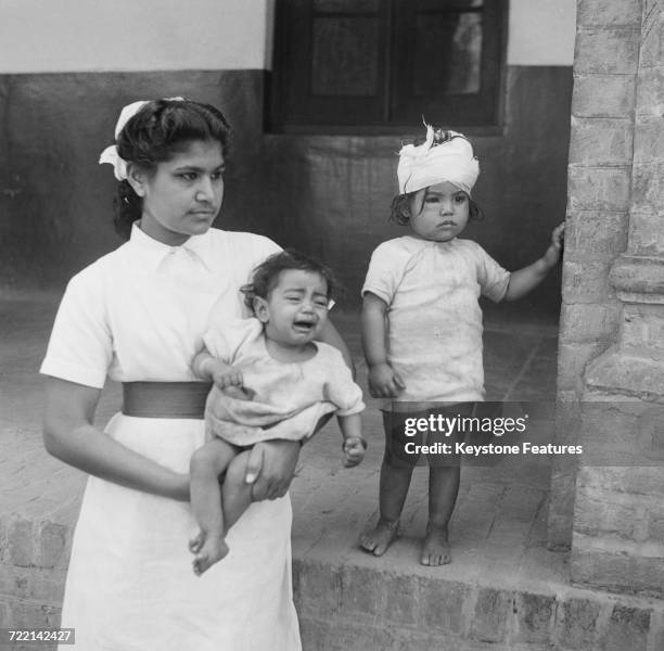 Nurse with two child victims of communal violence in Amritsar, Punjab, during the Partition of British India, March 1947. The children's mother was...