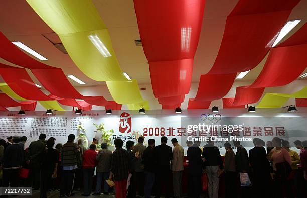 People visit an exhibition area promoting dishes for 2008 Beijing Olympics at Xian International Exhibition Center on October 19, 2006 in Xian of...