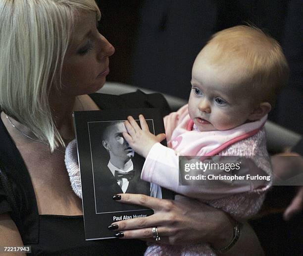 Lindsey Hunter, the wife of snooker star Paul Hunter cuddles their daughter Evie Rose during his funeral at Leeds Parish Church on October 19, 2006...