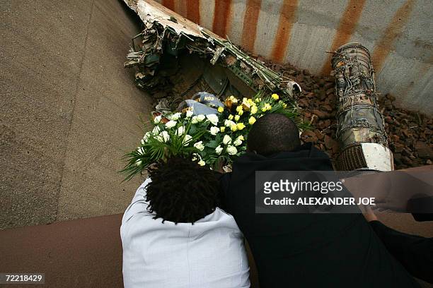 Members of Samora Machel's family lay a wreath of flower by airplane debris 19 October 2006 in Mbuzni at a memorial built on a hill where Samora...