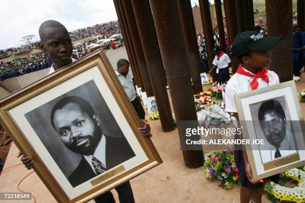 South African people hold a photo of late President Samora Machel and other victims of his plane crash 19 October 2006 in Mbuzni at a memorial built...