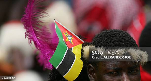 South African wears the Mozambican flag at a commemoration service 19 October 2006 in Mbuzini at the memorial on the hill where Mozambican President...