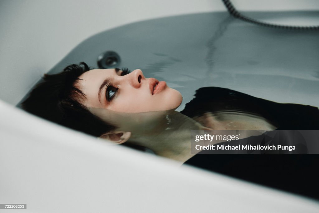 Caucasian woman wearing dress in bathtub