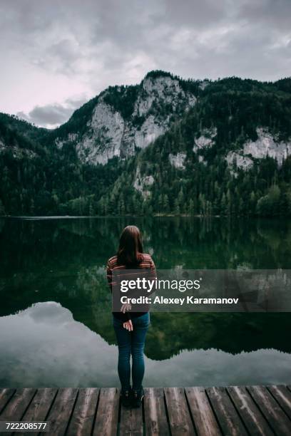 caucasian woman standing on dock admiring scenic view of mountain - spital am pyhrn stock pictures, royalty-free photos & images
