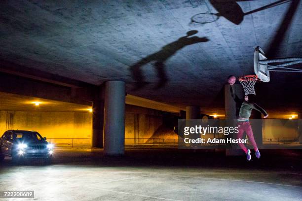 headlights shining on black man dunking basketball - trefferversuch stock-fotos und bilder