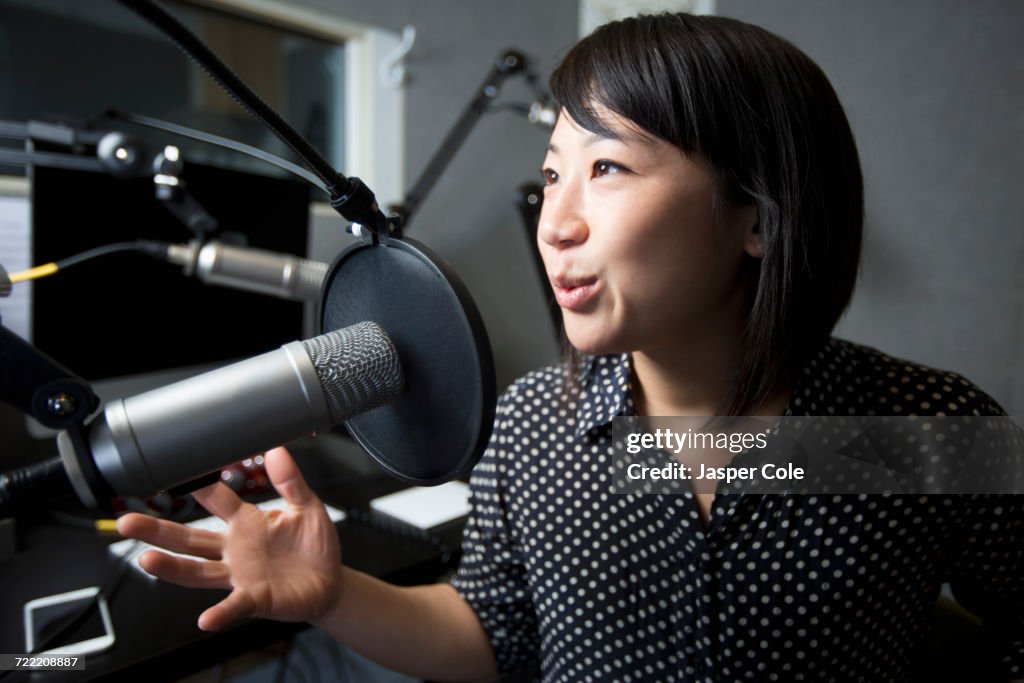 Asian woman talking into microphone