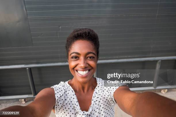 african american woman smiling for selfie - frauen mit fotoapparat stock-fotos und bilder