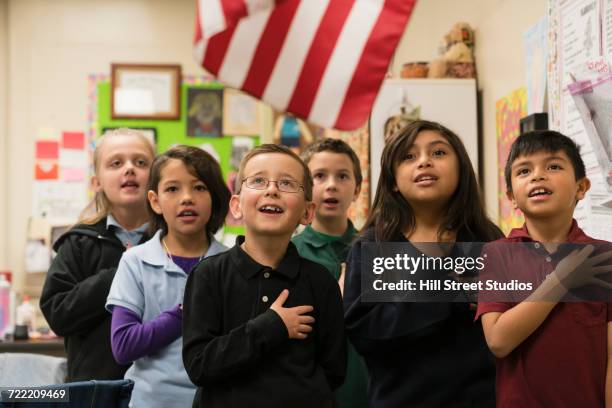 students standing for pledge of allegiance - amerikanischer treueschwur stock-fotos und bilder