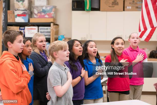 students standing for pledge of allegiance - amerikanischer treueschwur stock-fotos und bilder