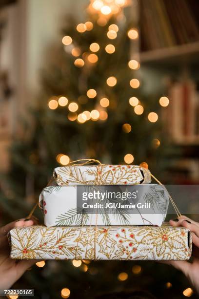 hands of caucasian woman holding christmas gifts - gift lounge stock-fotos und bilder