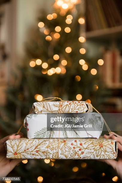 hands of caucasian woman holding christmas gifts - gift lounge foto e immagini stock