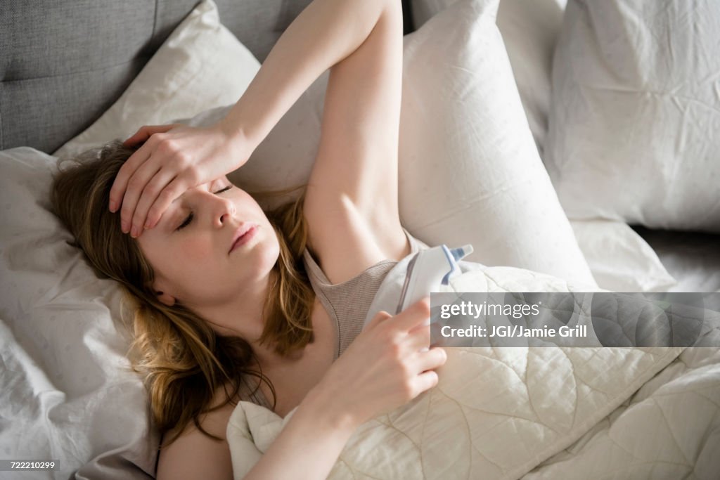 Woman laying in bed with headache