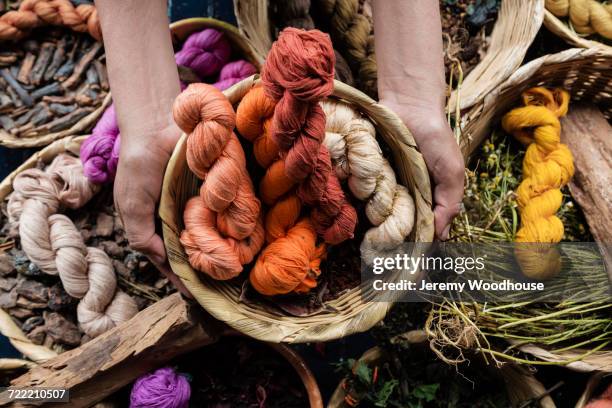 hands holding basket of naturally dyed cotton - mani fili foto e immagini stock