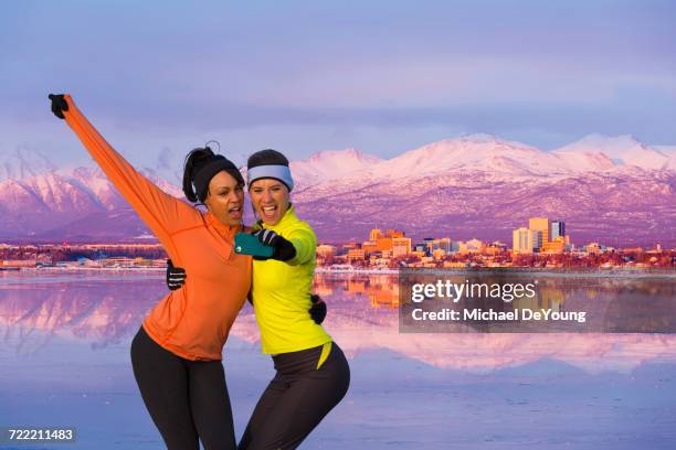 women posing for cell phone selfie near mountain river - anchorage alaska photos et images de collection