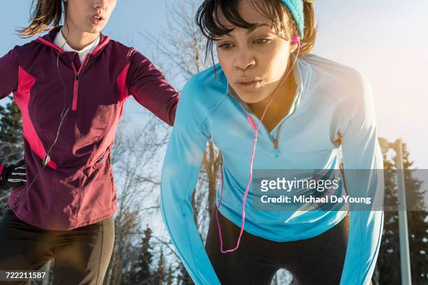 runners listening to earbuds and resting - 息切れ ストックフォトと画像