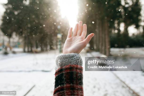 hand of caucasian woman catching falling snow - catching snow stock pictures, royalty-free photos & images