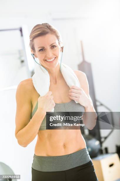 woman resting with towel around neck in gymnasium - after workout towel happy stock pictures, royalty-free photos & images