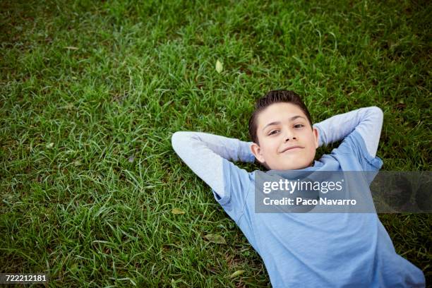 smiling hispanic boy laying in grass - zapopan stock pictures, royalty-free photos & images