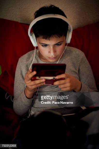 hispanic boy listening to cell phone with headphones - zapopan stock pictures, royalty-free photos & images