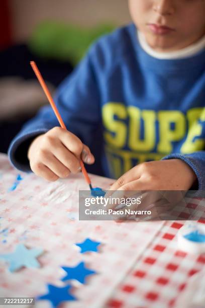 hispanic boy painting stars at table - zapopan stock pictures, royalty-free photos & images