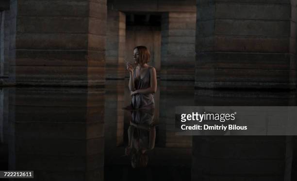 caucasian woman standing in water smoking cigarette - basement flood stock pictures, royalty-free photos & images