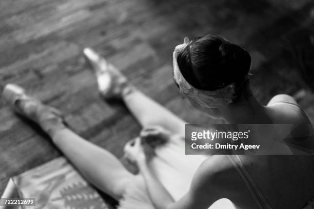 woman sitting on floor wearing ballet shoes - ballet dancers russia stockfoto's en -beelden