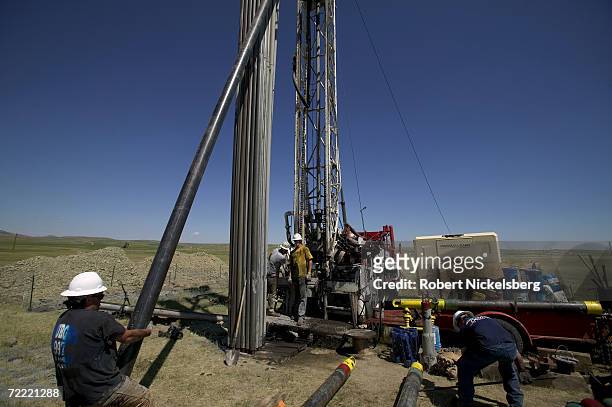 Laborers move 10" casing pipe to a drilled coal bed methane well before cement is pumped down lining and completing a well on June 14, 2006 in the...